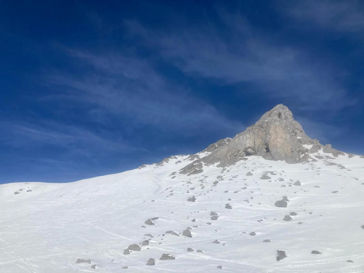 Verschneiter Hang unter dem markanten Felsgipfel der Aples-Pleisspitze.