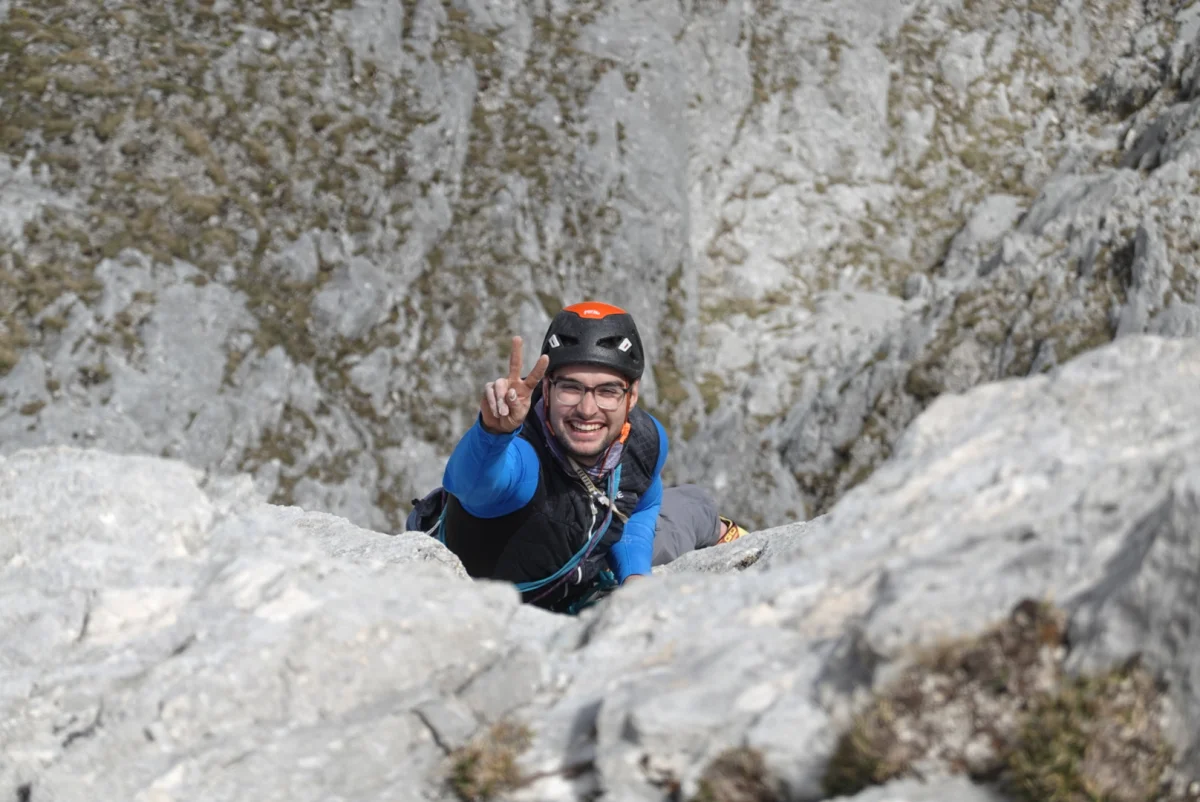 Lächelnder Kletterer mit Helm und Brille in der Route Reconquista an der Gehrenspitze.