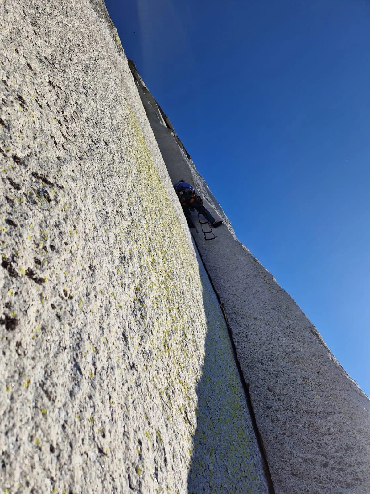 Kletterer hoch oben in einem markanten Granitriss am Half Dome.