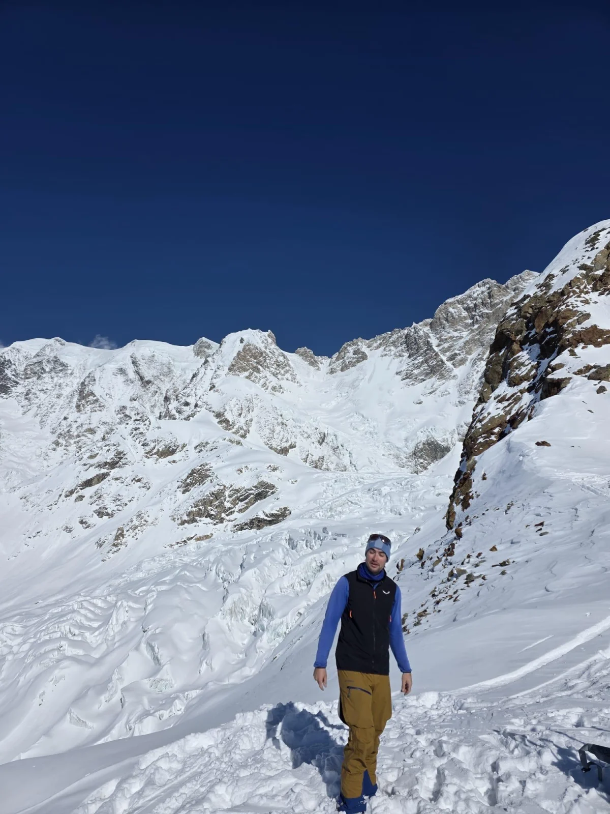 Bergsteiger im verschneiten Hochgebirge Swanetiens unter blauem Himmel.