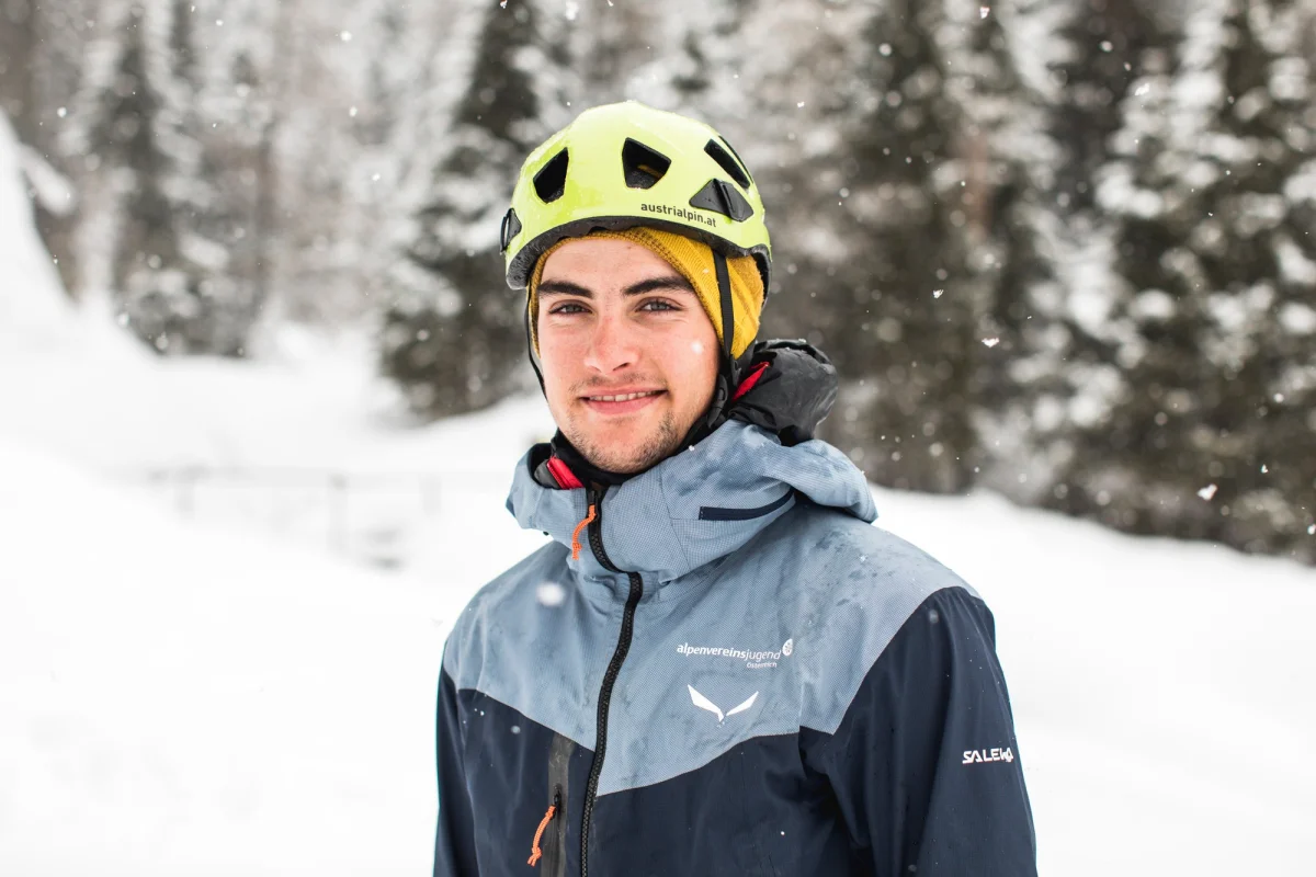 Ludwig Sandhacker mit gelbem Kletterhelm in einer Winterlandschaft.