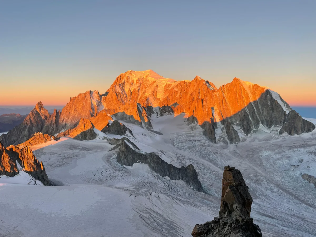 Sunlit peaks above a glacier in evening light.