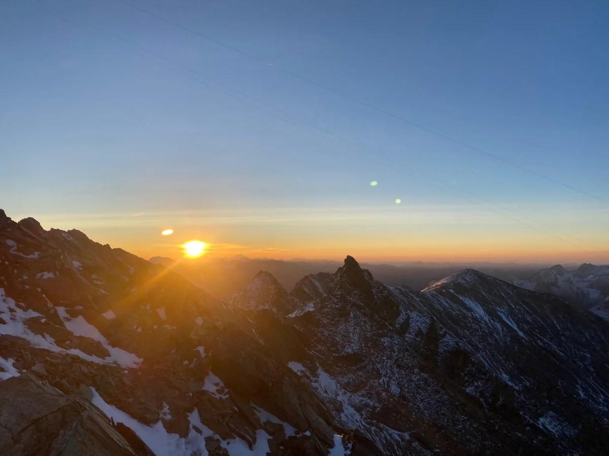 Beginner-Friendly Glacier and Mountaineering Course: Sunrise over rocky and snow-covered mountain peaks.