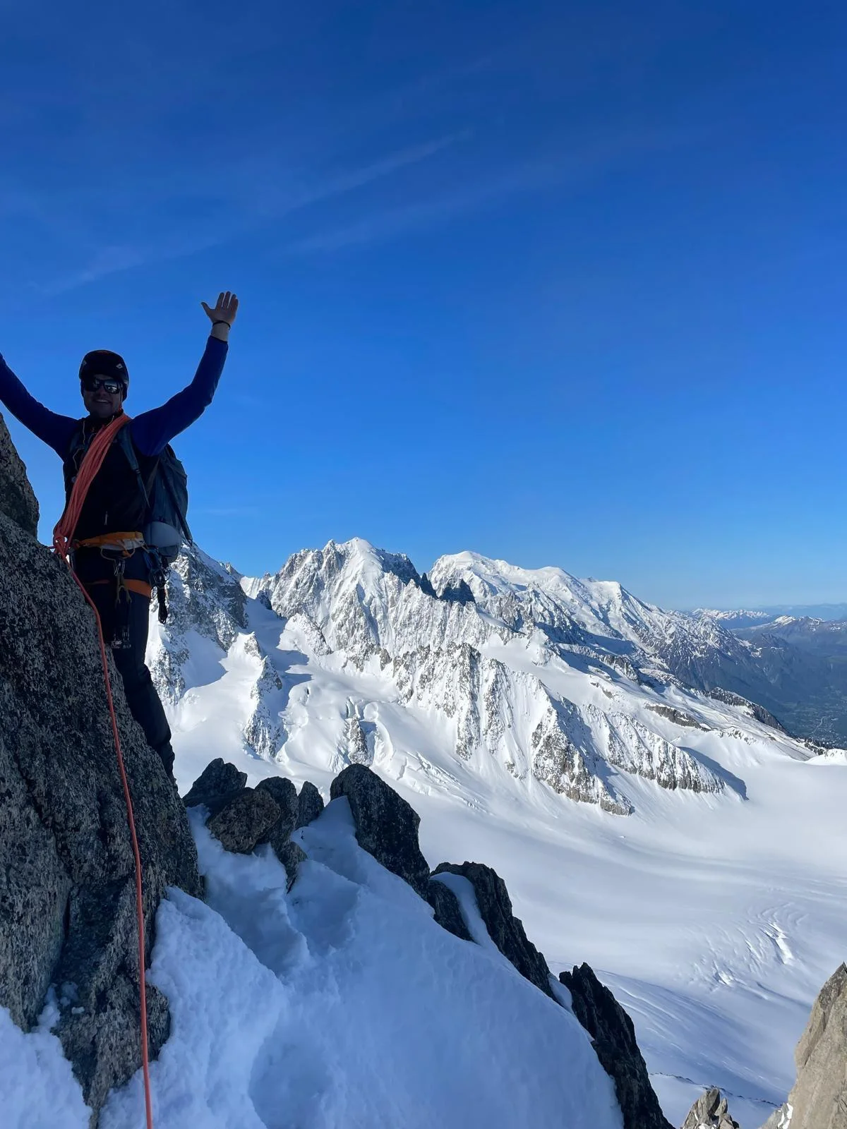 Arête de la Table on Aiguille du Tour: Mountaineer raising an arm in front of snowy peaks.