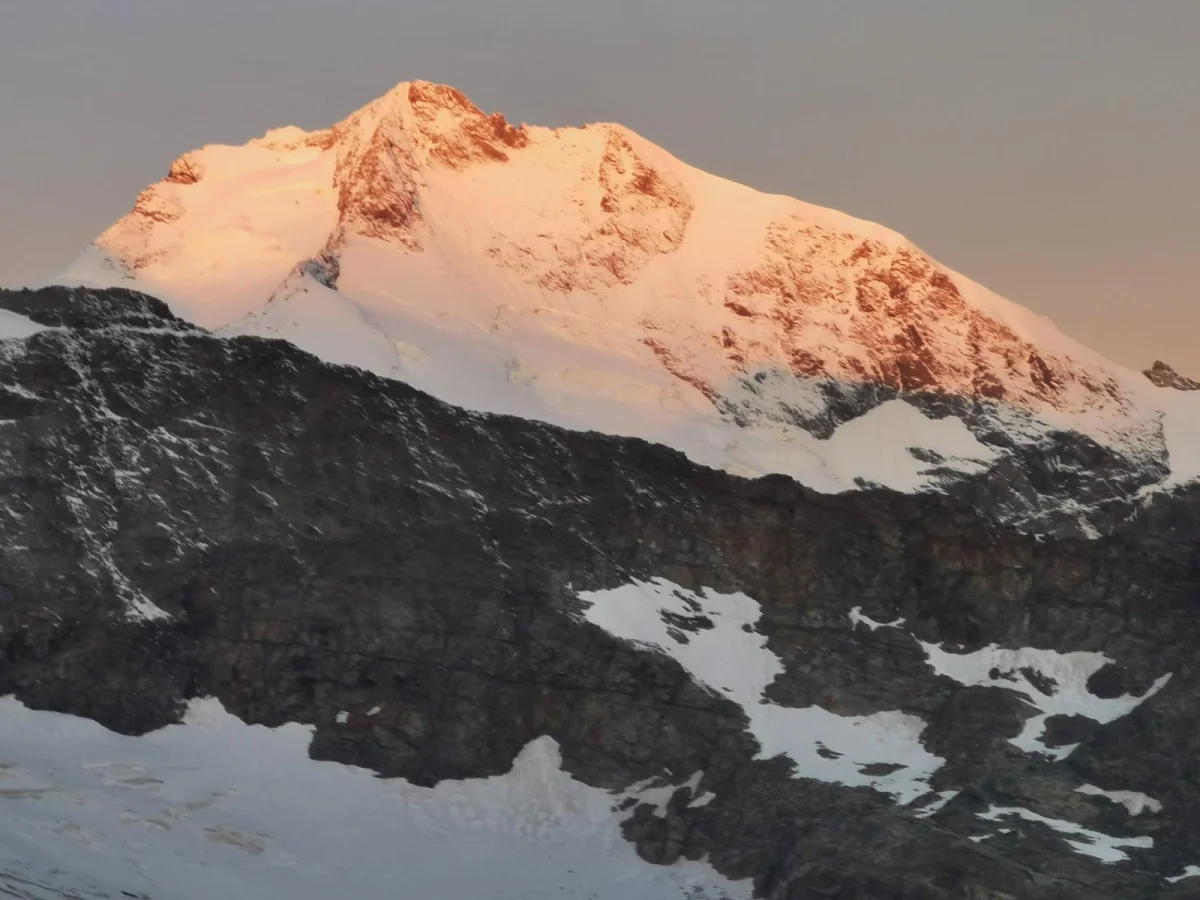 Biancograt auf den Piz Bernina: Verschneiter Berggipfel im warmen Morgenlicht.