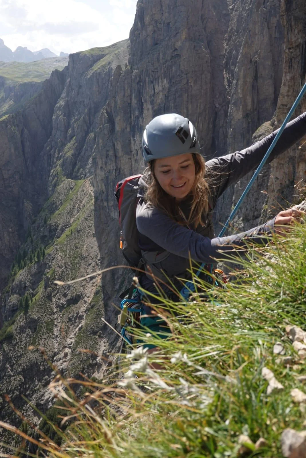 Burgstallkante – Dolomite Classic with Mountain Guide: Helmeted climber at the grassy exit of a rock route.