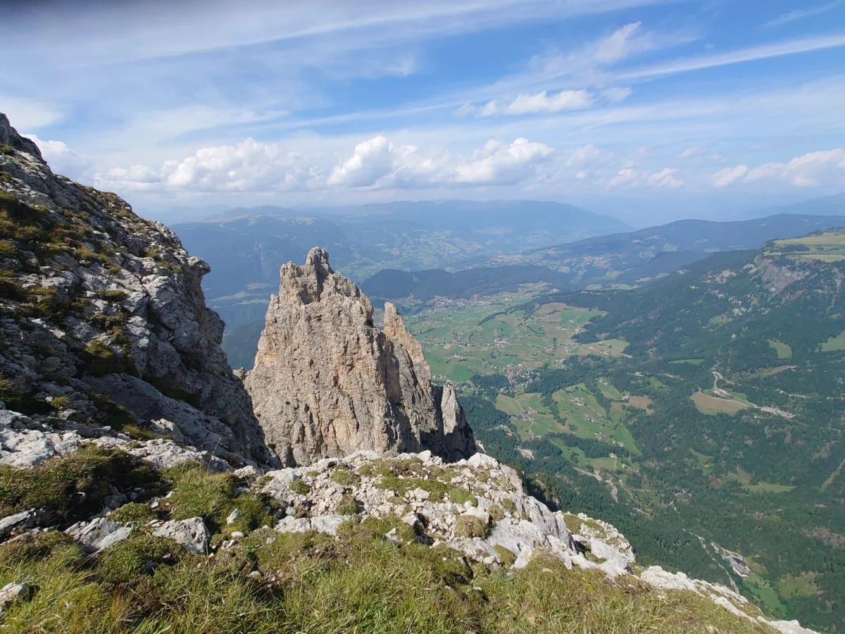 Burgstallkante – Dolomite Classic with Mountain Guide: View from a rocky ridge across Dolomite peaks and alpine meadows.