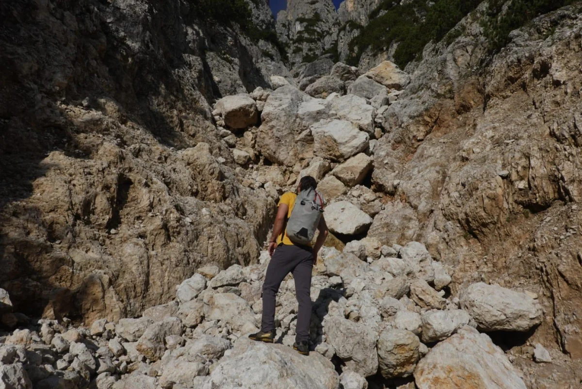 Burgstallkante – Dolomite Classic with Mountain Guide: Mountaineer with a backpack on a rocky approach.
