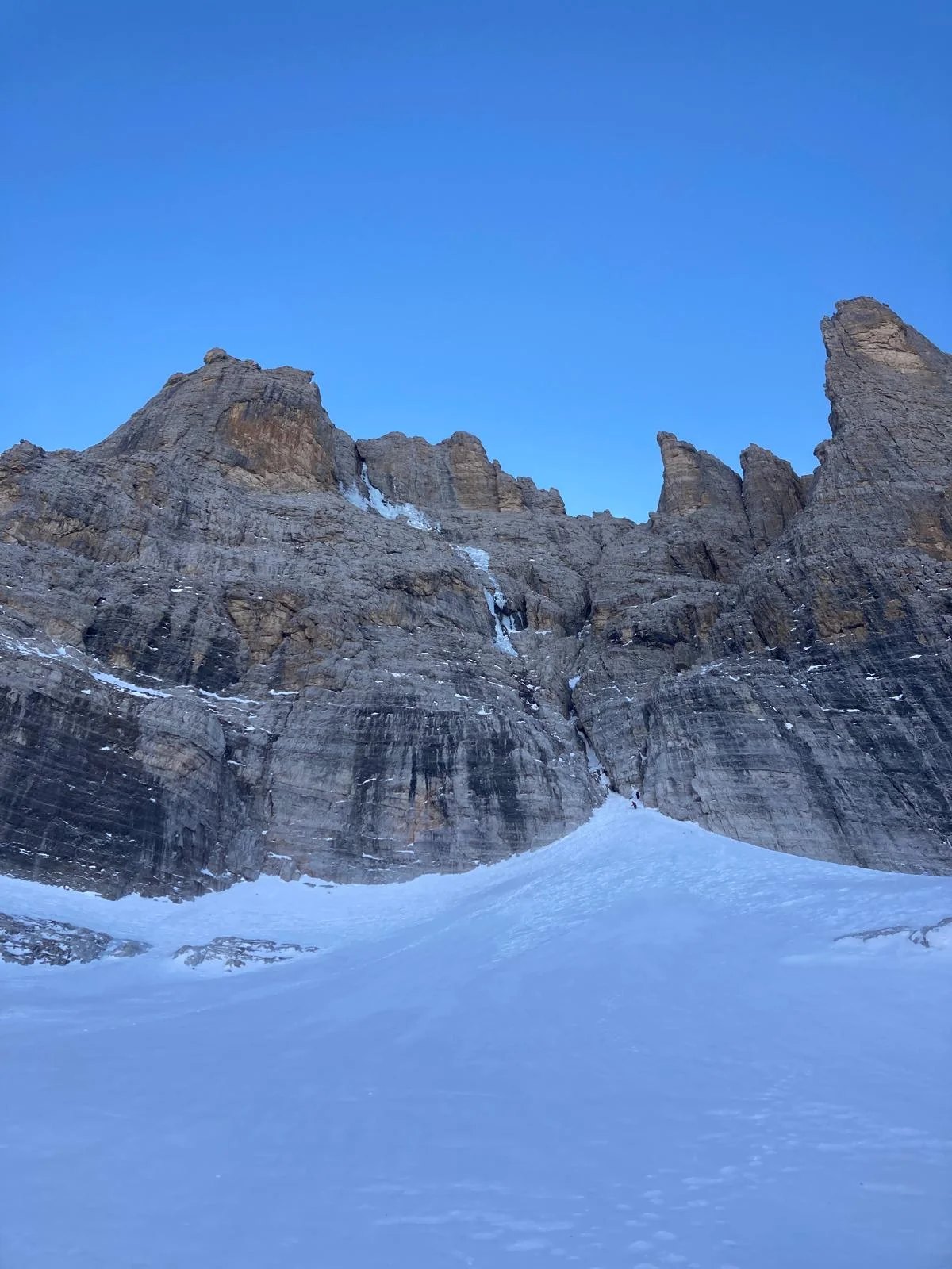 Der Weg den es nicht gibt - Cima Brenta Nordwand: Verschneite Dolomitenwand unter blauem Himmel.