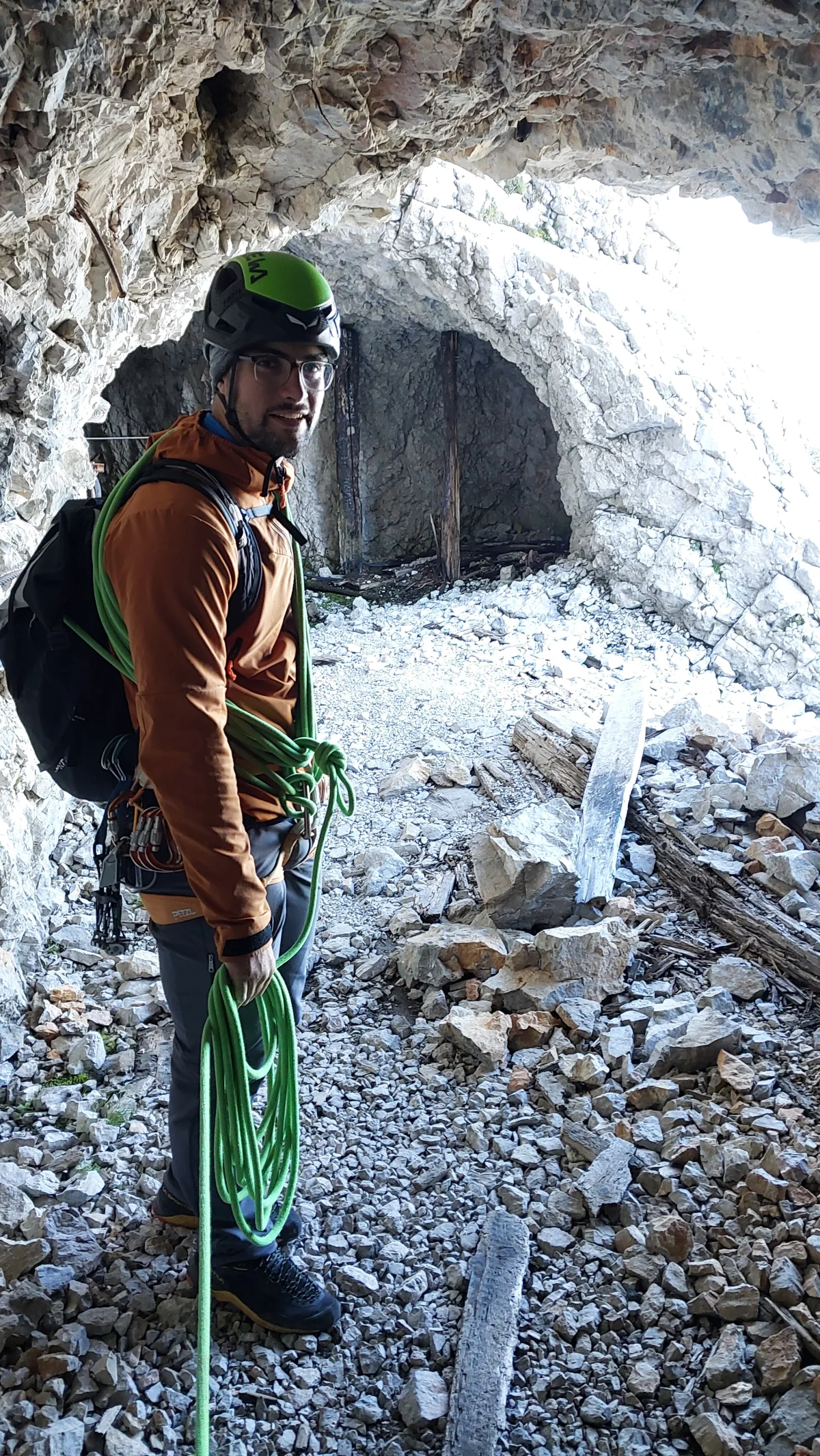 Eisenzeit – Zugspitze North Face: Mountaineer with helmet and rope in a rock tunnel.