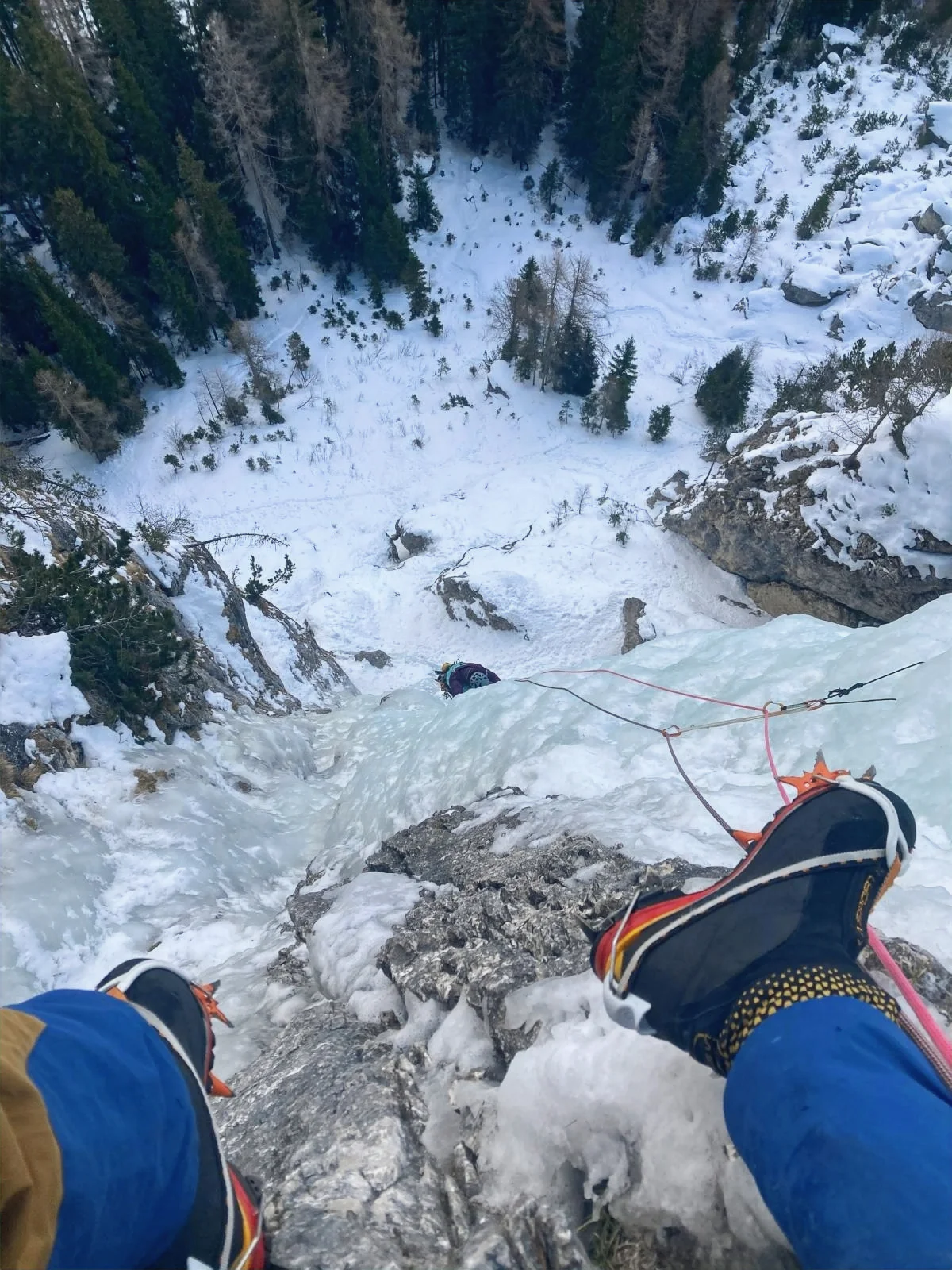 Eisklettern in Kolfuschg - mit Bergführer: Blick von Steigeisen über eine vereiste Kletterroute.