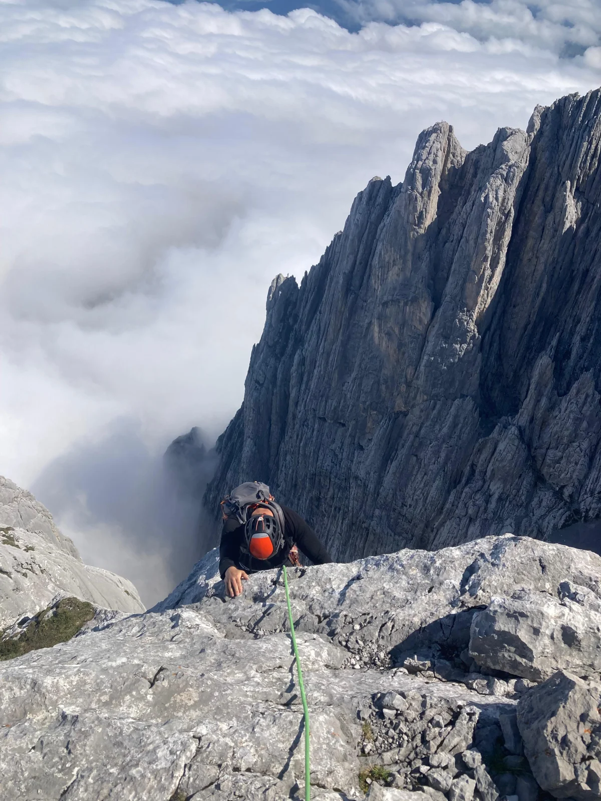 Fleischbank North Ridge – Climbing Tour with Mountain Guide in the Wilder Kaiser: Climber near a ridge above a sea of clouds.