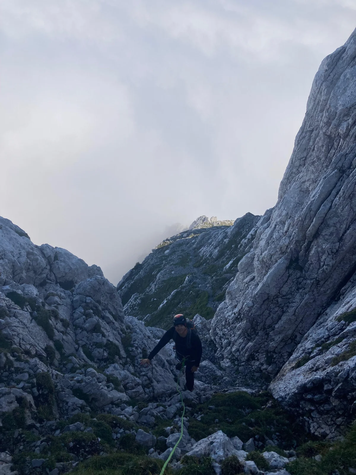 Fleischbank North Ridge – Climbing Tour with Mountain Guide in the Wilder Kaiser: Mountaineer on a rocky approach between high walls.