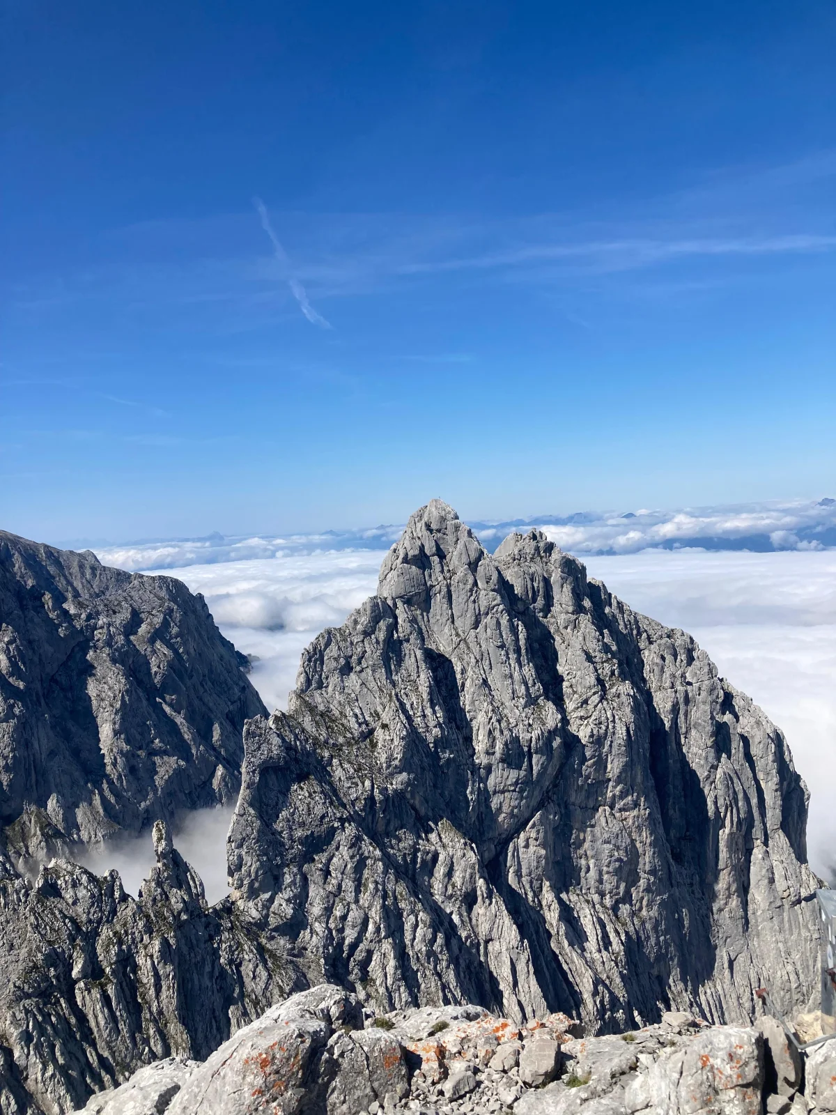 Fleischbank North Ridge – Climbing Tour with Mountain Guide in the Wilder Kaiser: View across rocky peaks above a sea of clouds.