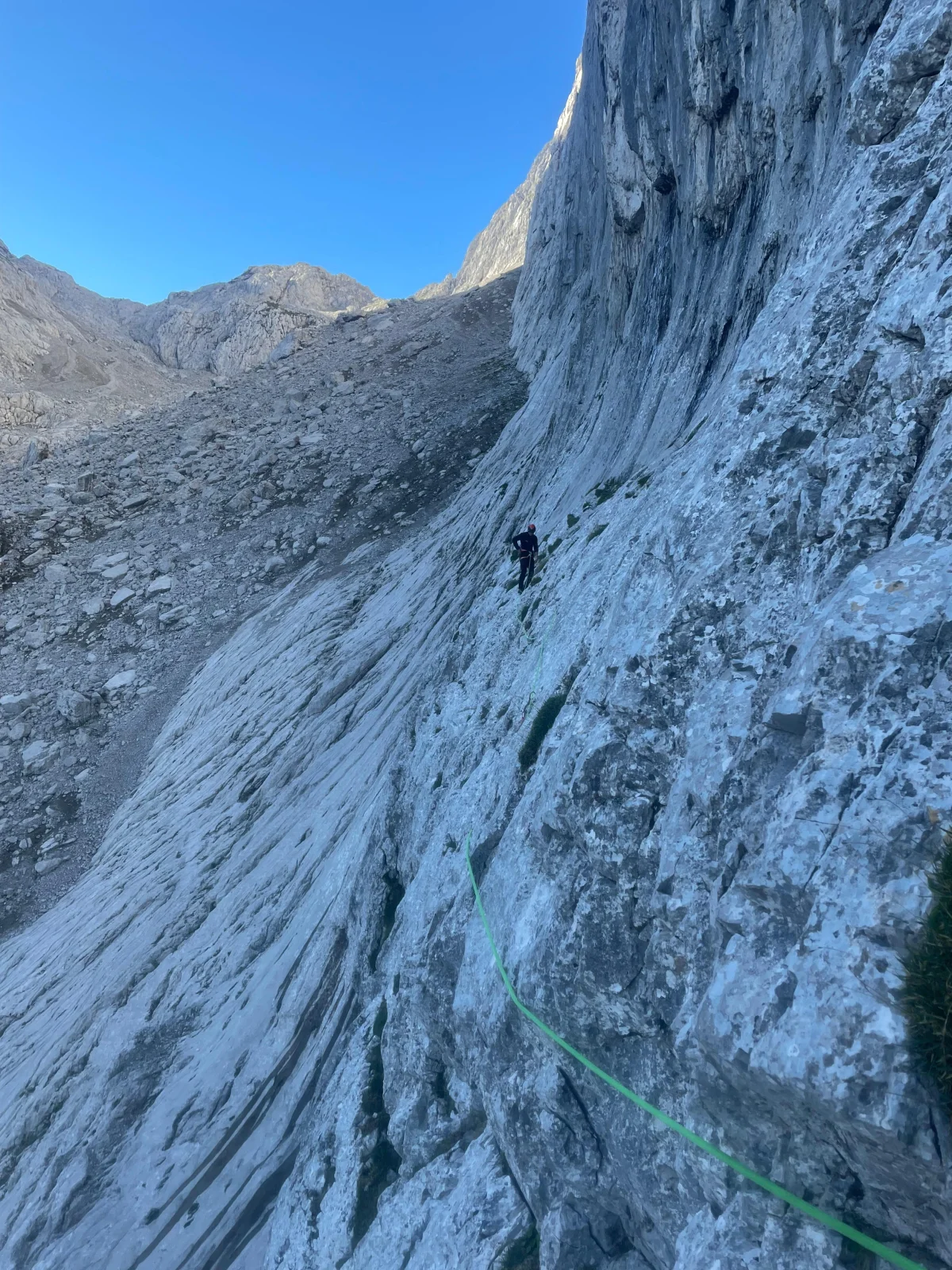 Fleischbank East Face – Dülfer Route: Climber traversing above a rock slab.
