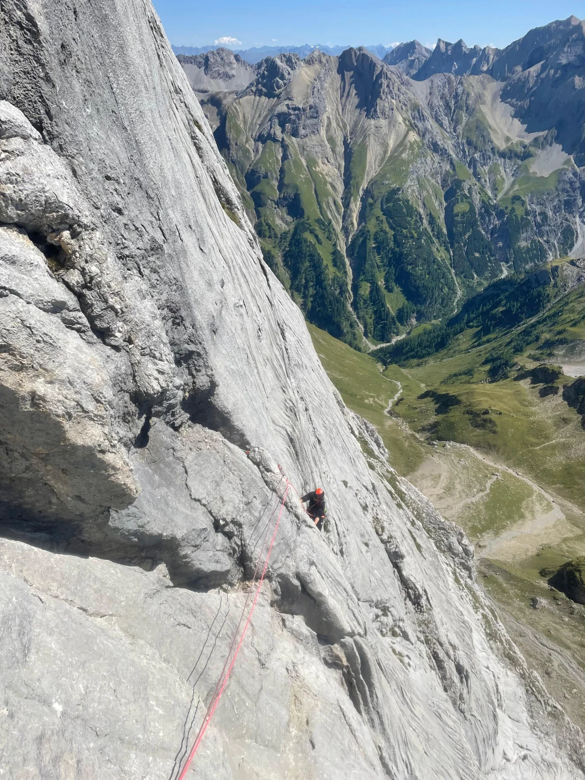 Freispitz South Face – Schreck Heel: View along a climbing rope across steep rock slabs.