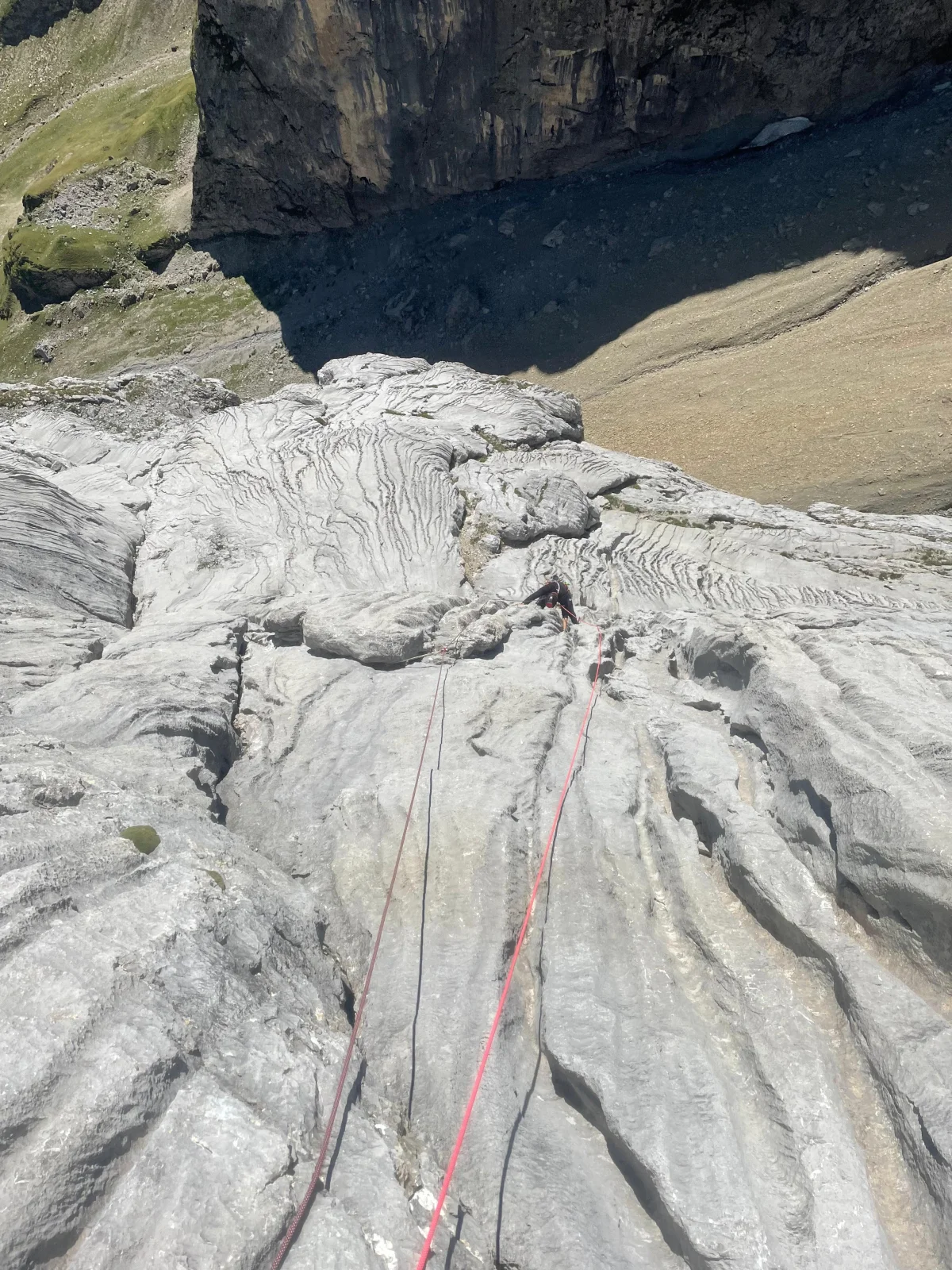 Freispitz South Face – Schreck Heel: View along a climbing rope across steep rock slabs.