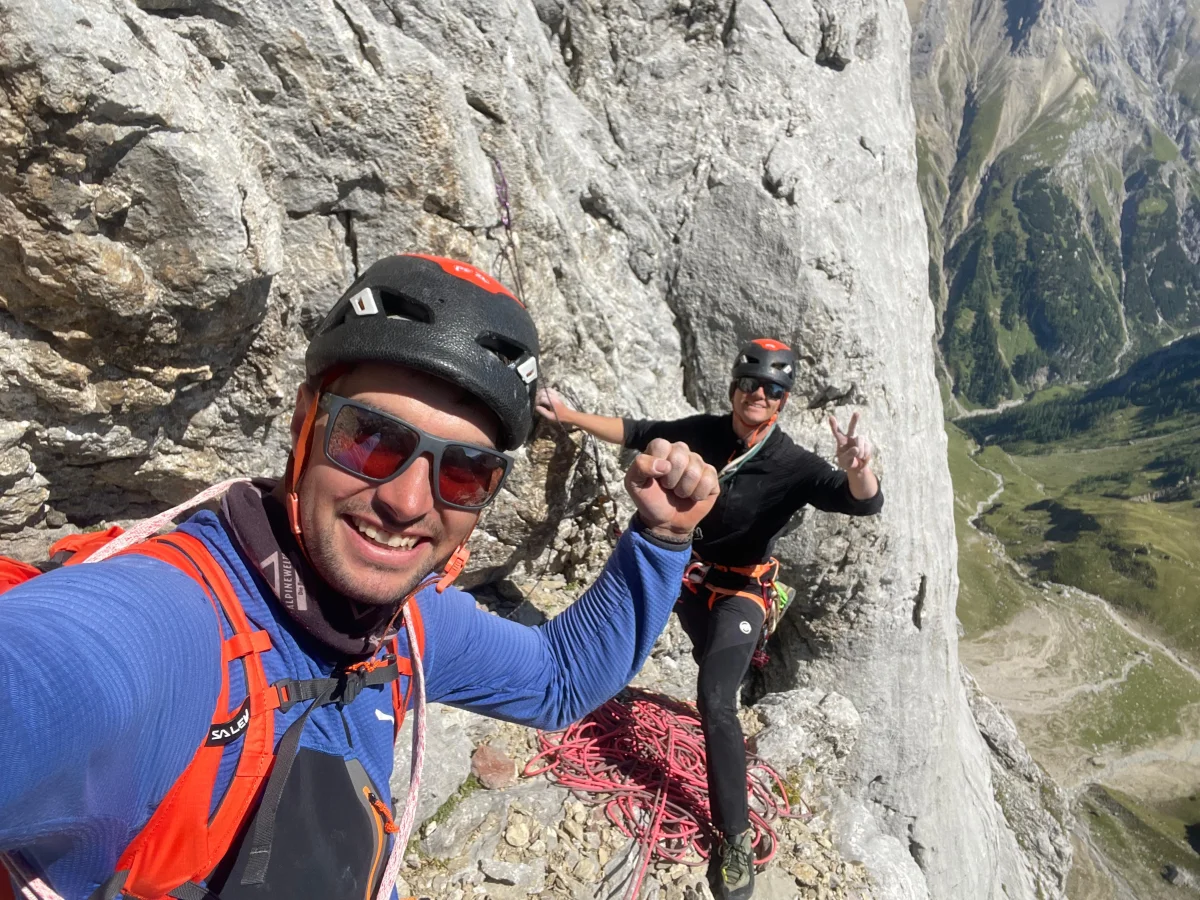 Freispitz South Face – Schreck Heel: Two smiling helmeted climbers at a belay.