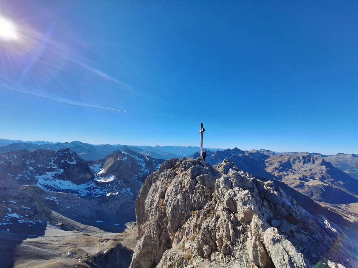 Summit cross on a rocky ridge with panoramic views of the mountains in the Lechtal valley.