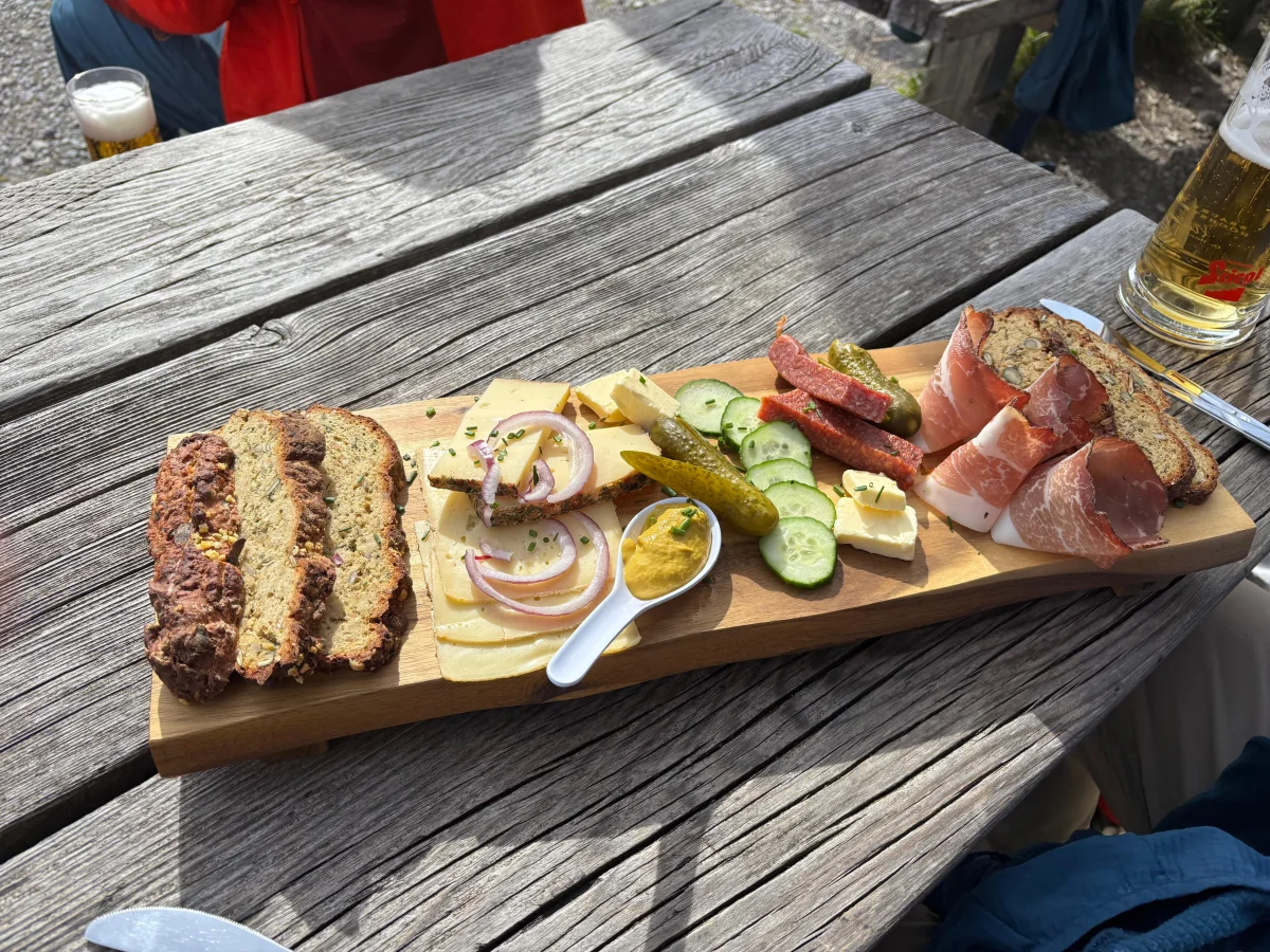 Bread, cheese and cold cuts on a sunny mountain hut terrace after climbing.