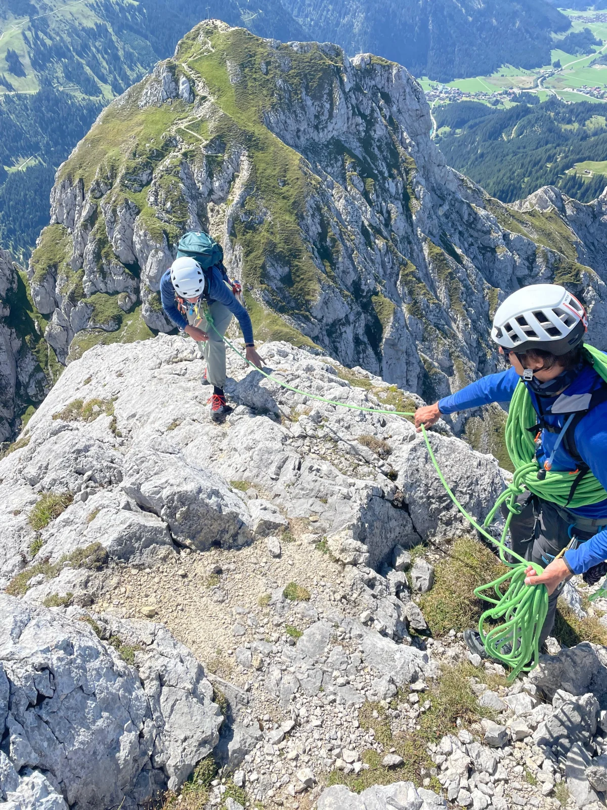 Gimpel West Ridge – Climbing Tour with Mountain Guide in the Tannheim Valley: Roped climbers on a summit overlooking green mountain slopes.