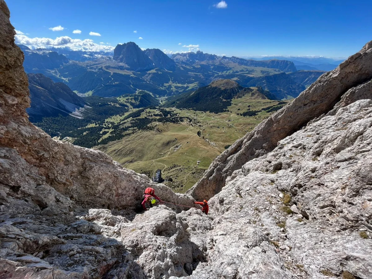 Große Fermeda Normal Route – with Mountain Guide: Roped mountaineers ascending rocky terrain with views of the valley.