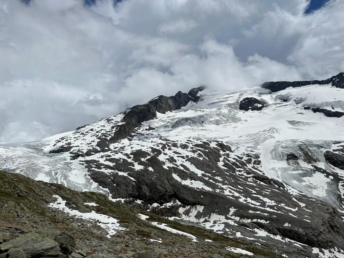 Großvenediger North Ridge with a Mountain Guide: Glacier and snow-covered mountain slopes beneath clouds.