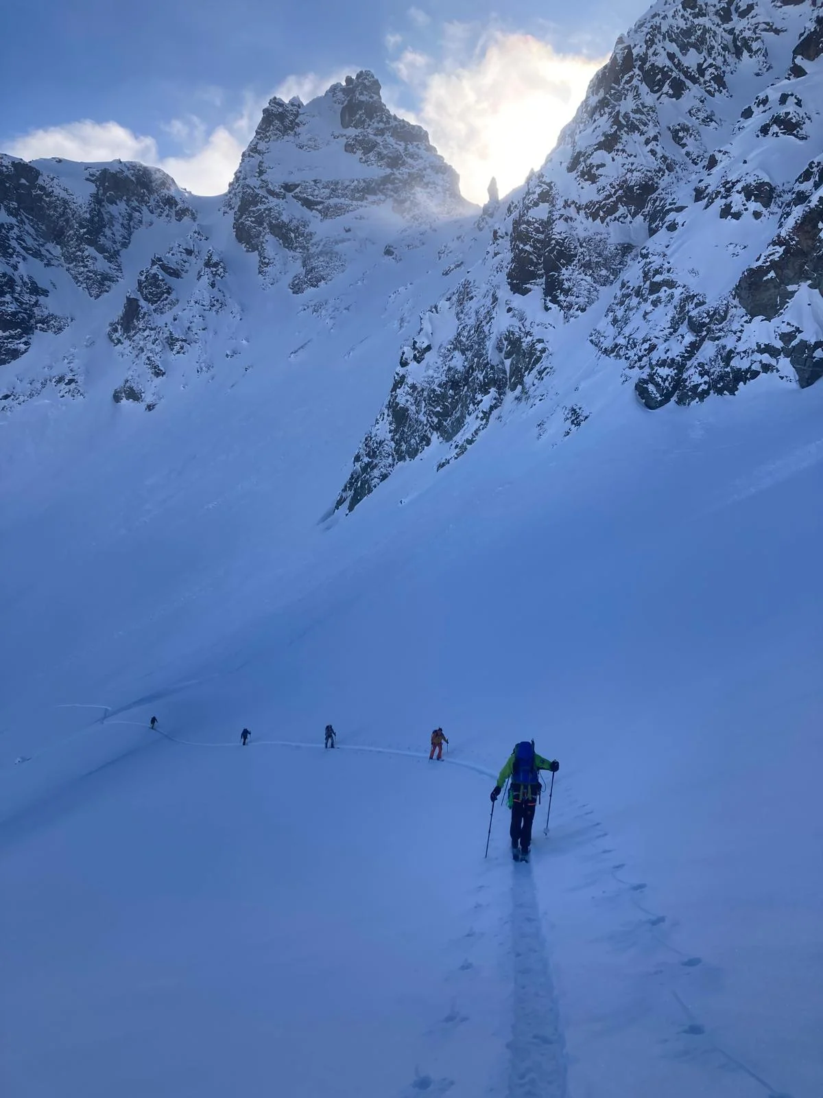 Individuelle Skidurchquerung in der Silvretta: Skitourengeher beim Aufstieg unter verschneiten Felsgipfeln.