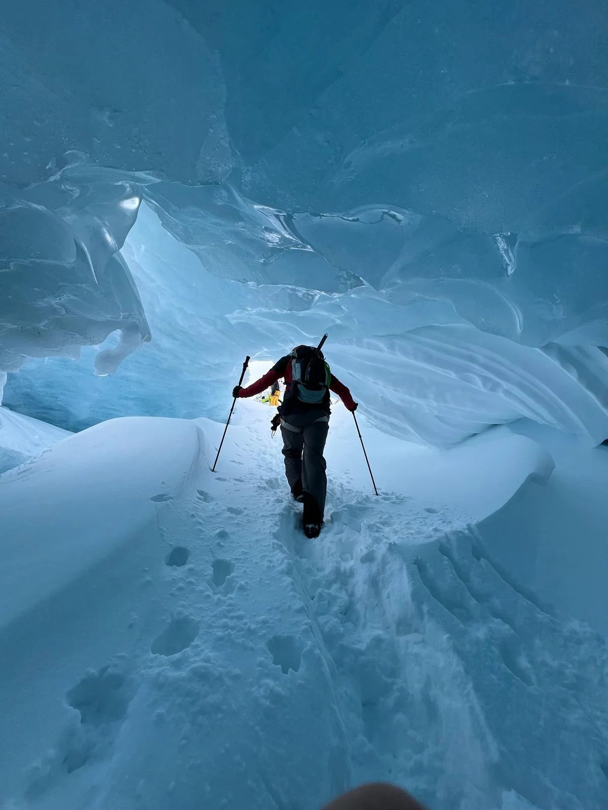 Individuelle Skidurchquerung in der Silvretta: Skitourengeher in einer blau schimmernden Eishöhle.