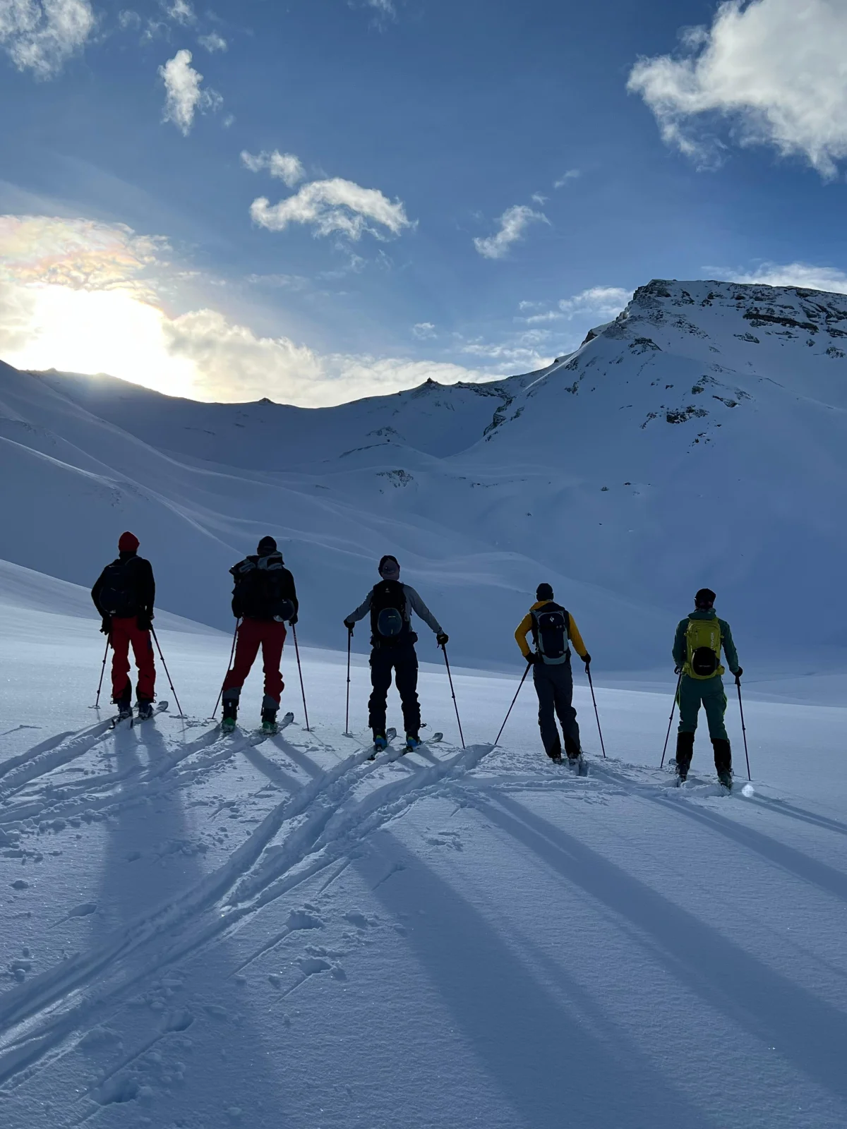 Custom Ski Traverse in the Silvretta: Ski touring group taking a break in front of snowy mountains.