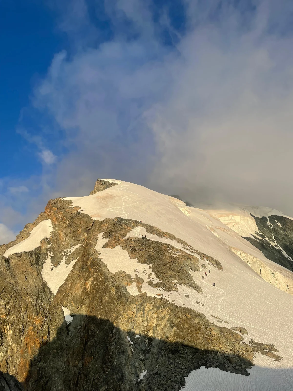 Easy 4,000-Meter Peaks in Saas-Fee: Glaciated summit beneath a blue sky and clouds.