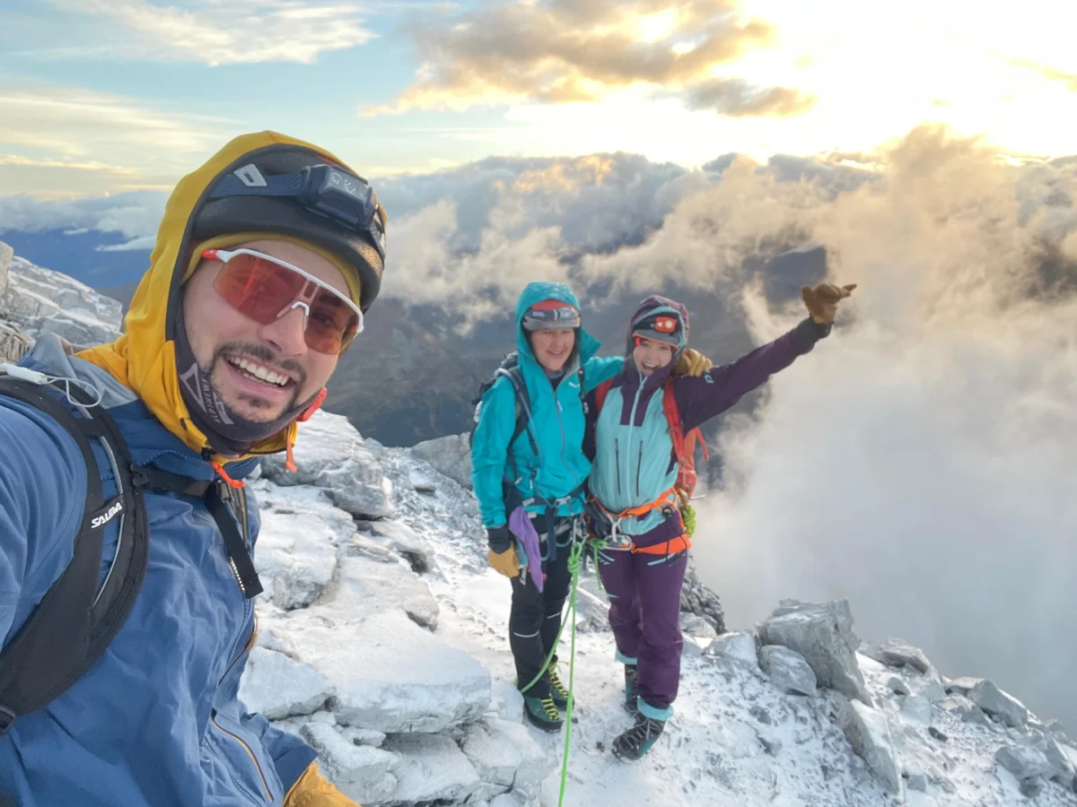 Ortler Hintergrat with a Mountain Guide: Three smiling mountaineers on a snowy summit.