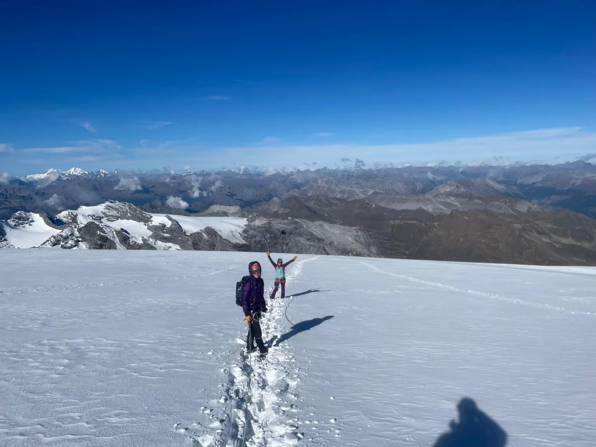 Ortler Hintergrat with a Mountain Guide: Roped mountaineers following a trail across a broad glacier.