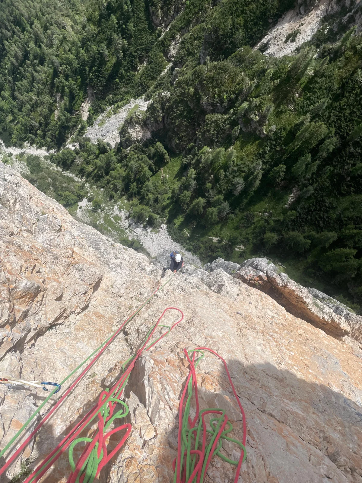 Palfrader on the Geierwand in Toblach – Steep Alpine Climb in the Dolomites: Climbing ropes at a belay overlooking a green valley.