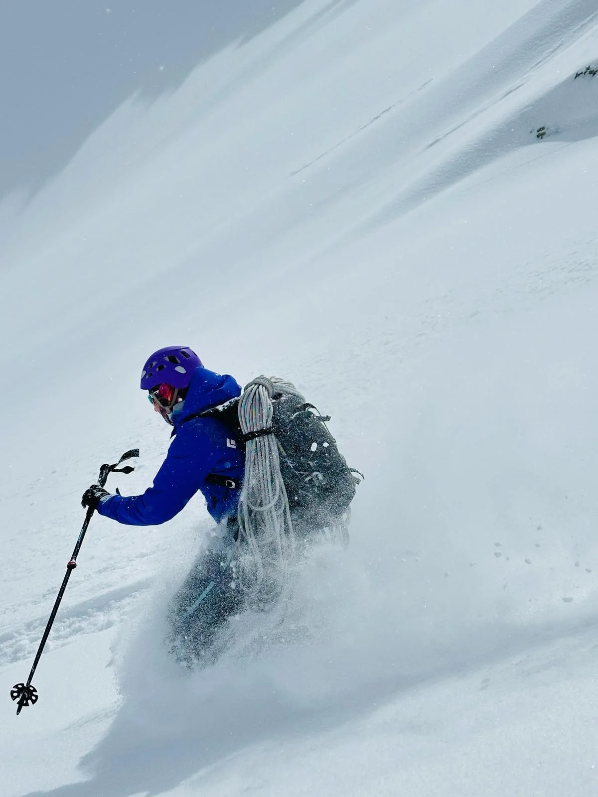 Ski Mountaineering on the Franz Senn Hut: Skier in a blue jacket descending through powder snow.