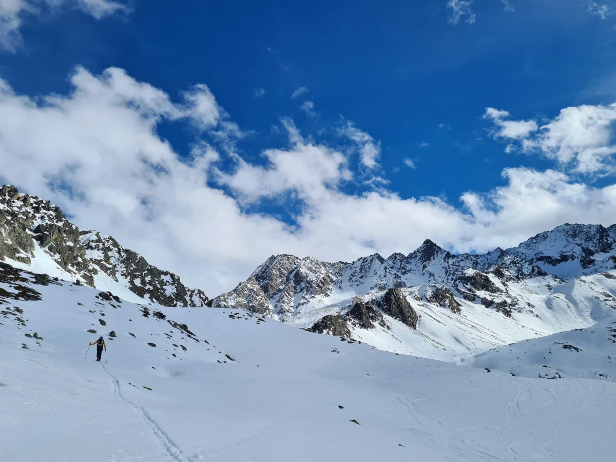 Ski Mountaineering on the Franz Senn Hut: Snow-covered alpine valley beneath rocky mountain peaks.