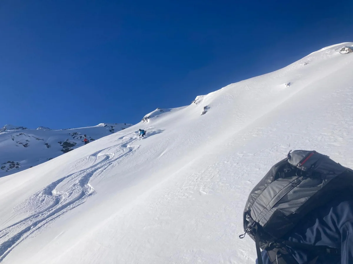 Ski Touring in Sellrain with a Mountain Guide: Ski tracks and a backpack on a sunlit snow slope.