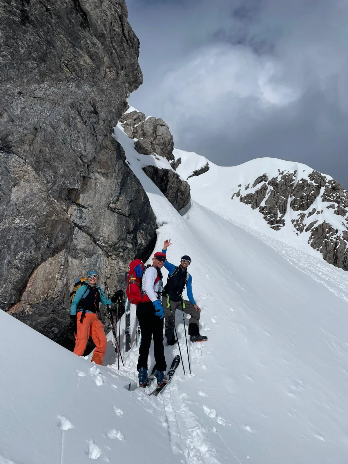 Ski Touring in Sellrain with a Mountain Guide: Ski touring group taking a break beside a rock wall.