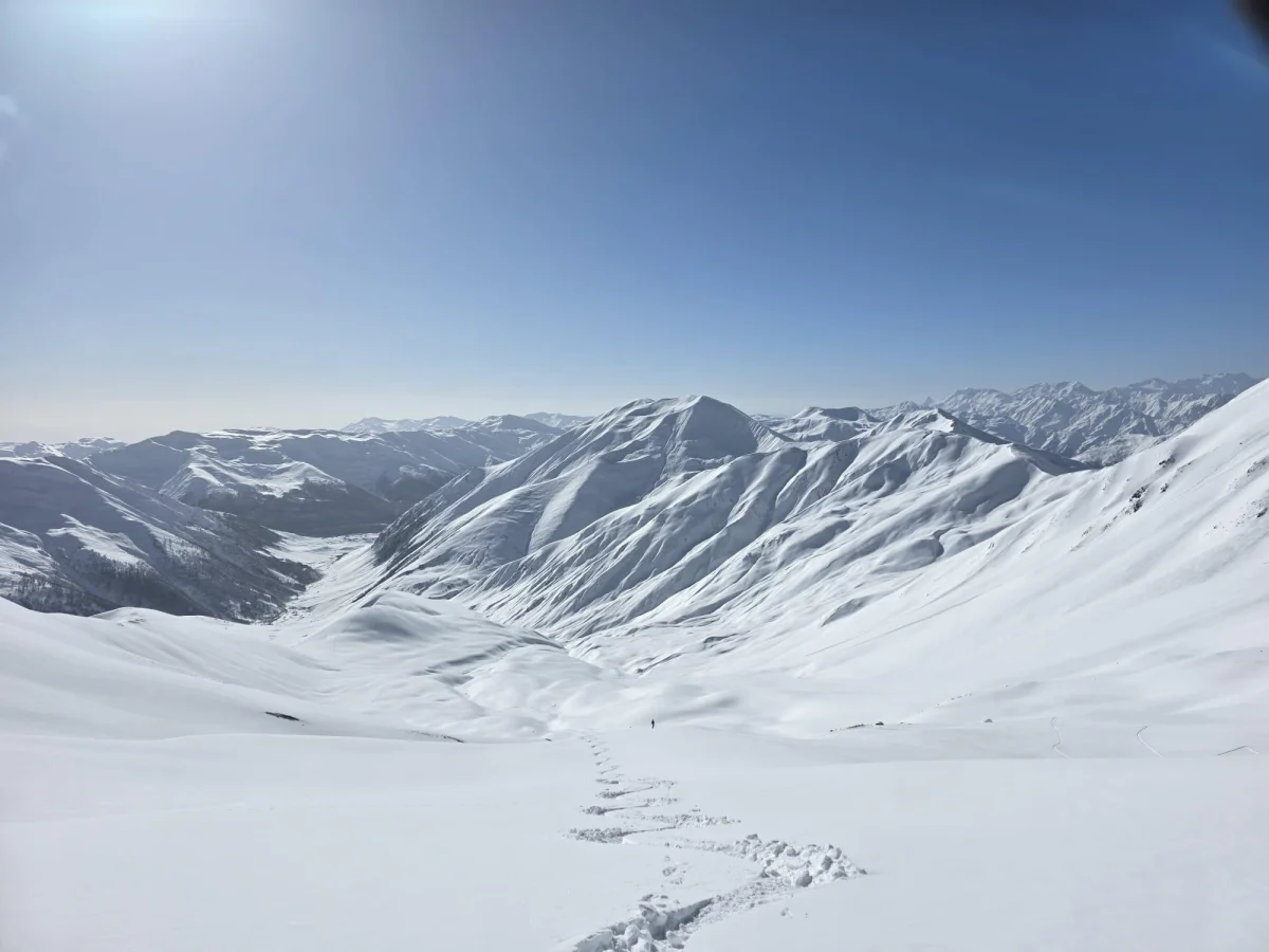 Skitouren in Georgien - Ushguli - Svanetien: Weites verschneites Gebirgstal mit einer einzelnen Skispur.