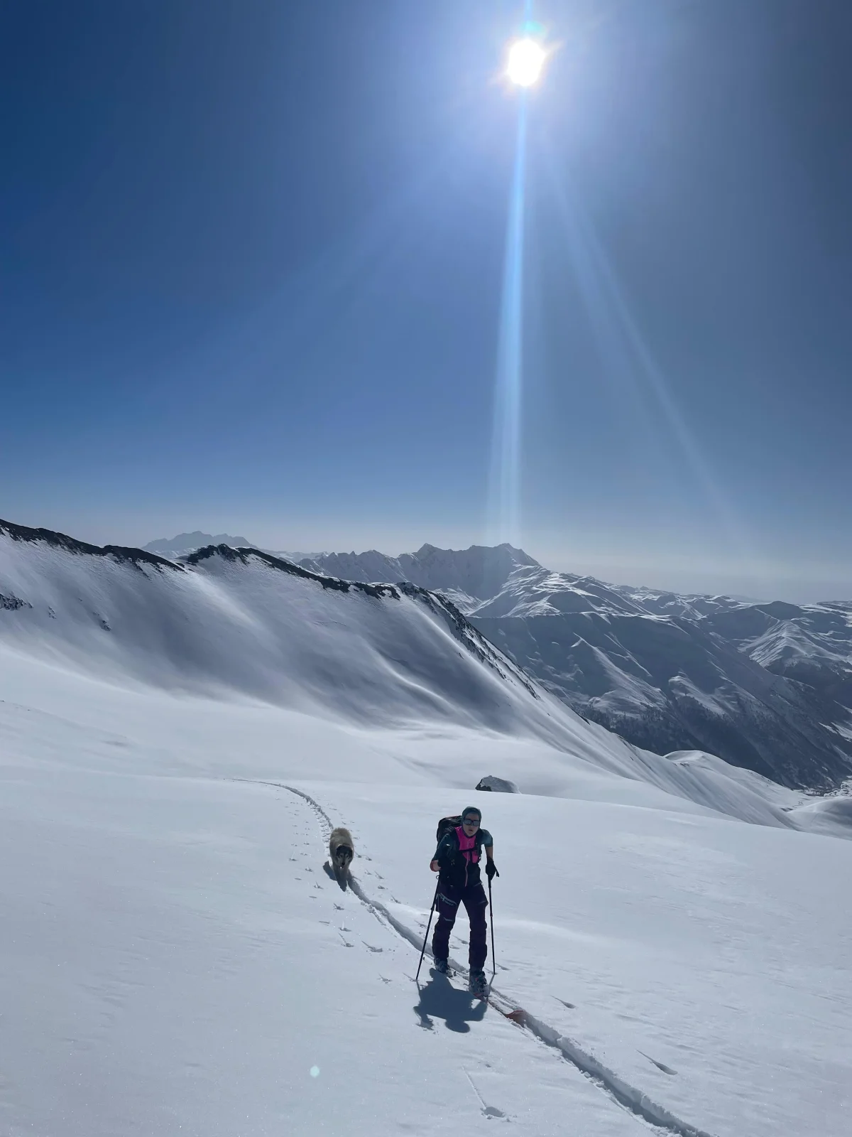 Skitouren in Georgien - Ushguli - Svanetien: Skitourengeher bei einer Pause auf einer sonnigen Schneefläche.