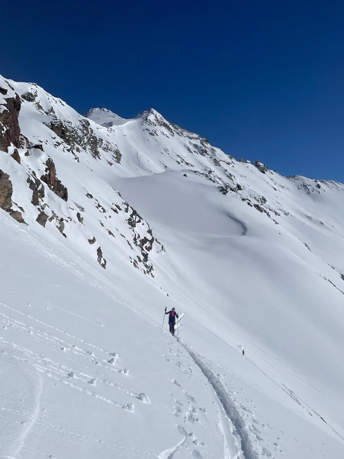 Skitouren in Georgien - Ushguli - Svanetien: Skitourengeher beim Aufstieg unter schneebedeckten Felswänden.