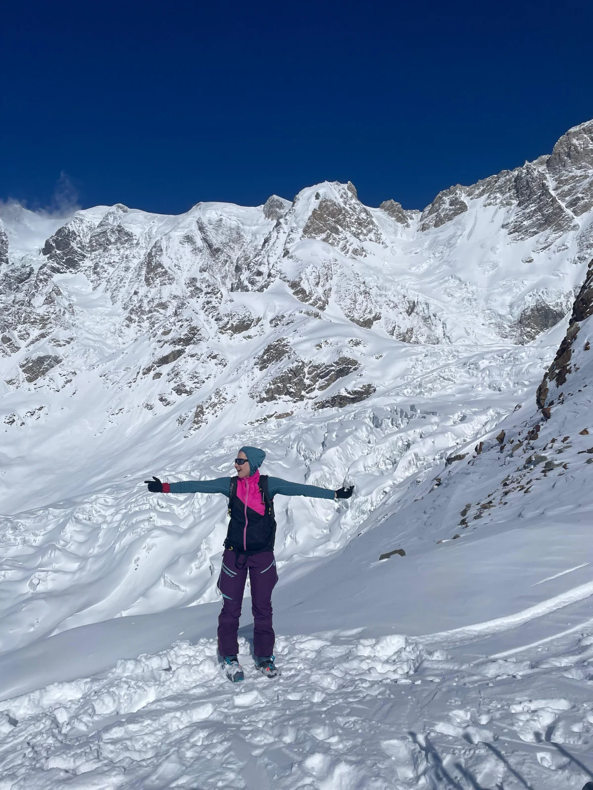 Skitouren in Georgien - Ushguli - Svanetien: Skifahrerin mit ausgestreckten Armen vor Abfahrtsspuren.