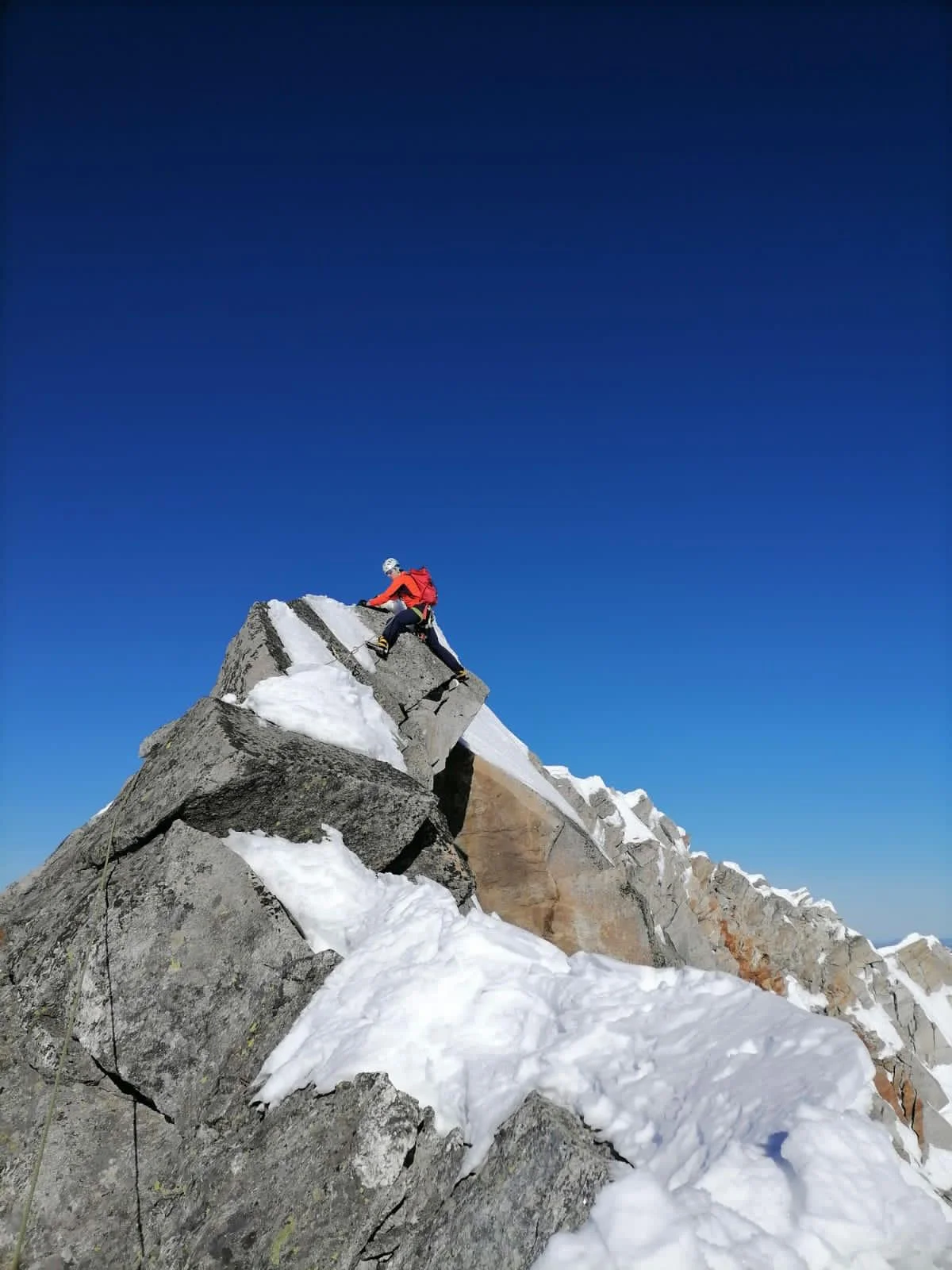 Turnerkamp South Ridge: Mountaineer wearing a red helmet on a rocky ridge.