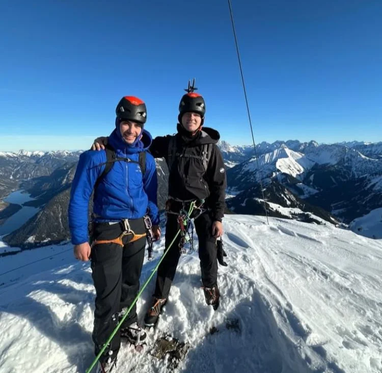Winter Mountaineering on Thaneller: Two helmeted mountaineers on a snowy summit.